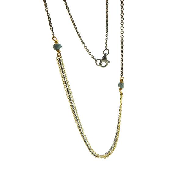 Elegant halskæde med guld og sort rhodium, to blå-grønne rå diamanter og en tydelig lukning.